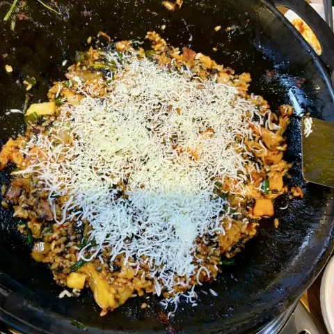 スノーフレークとろ〜りチーズチャーハン - タッカルビ体験の伝説的なフィナーレ。残ったソースで炒めたご飯の上に、新雪を思わせる細切りとろ〜りチー...